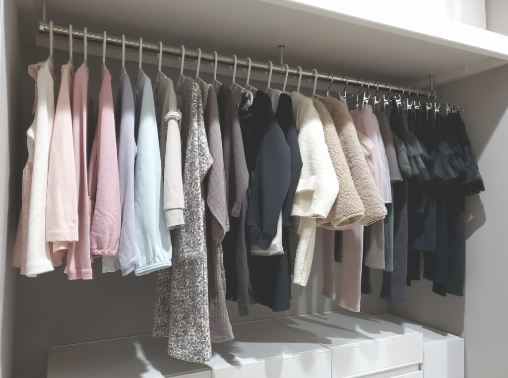 洋服がかかったクローゼットの画像