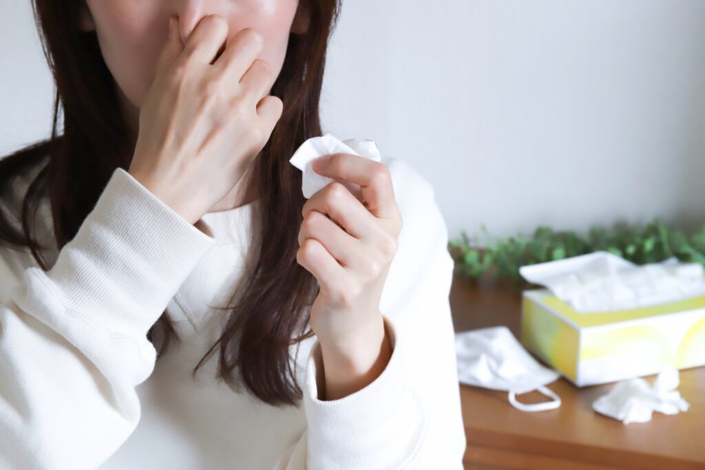 大掃除でやってはいけない行動6　アレルギーで鼻をかむ女性の画像