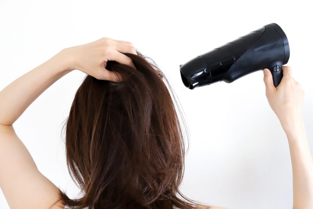 ヘアケアの正しいやり方 ドライヤーで乾かす女性