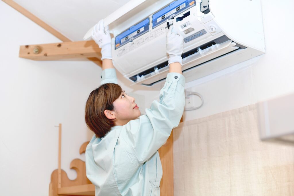 エアコンクリーニング完全ガイド エアコンを点検する女性