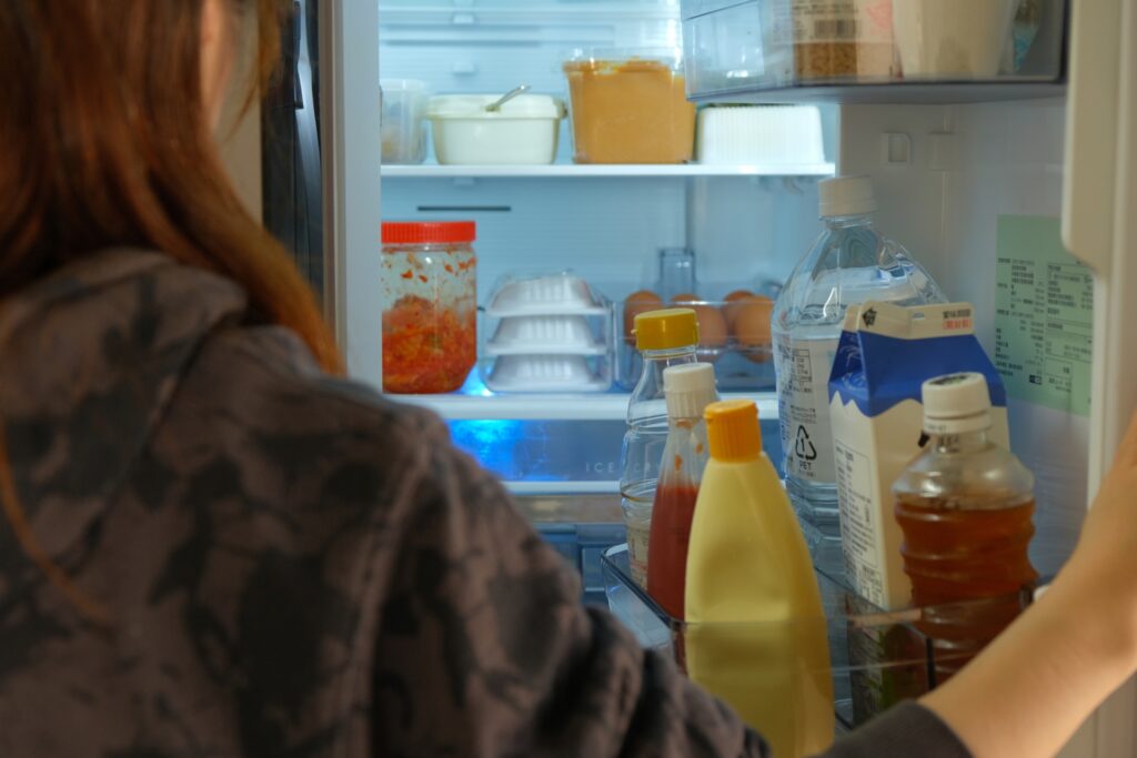 冷蔵庫の中を見る女性