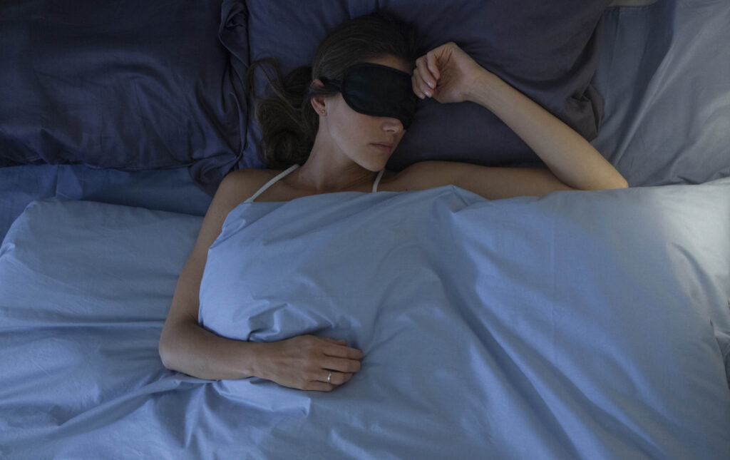 アイマスクして眠る女性の画像