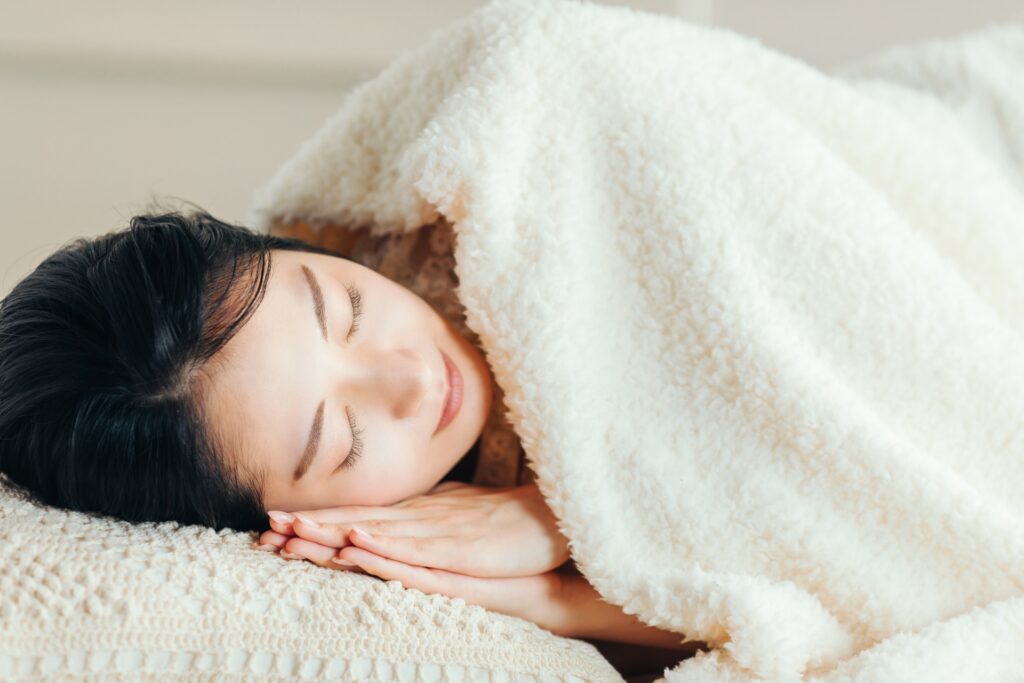 ベッドで眠る女性の画像